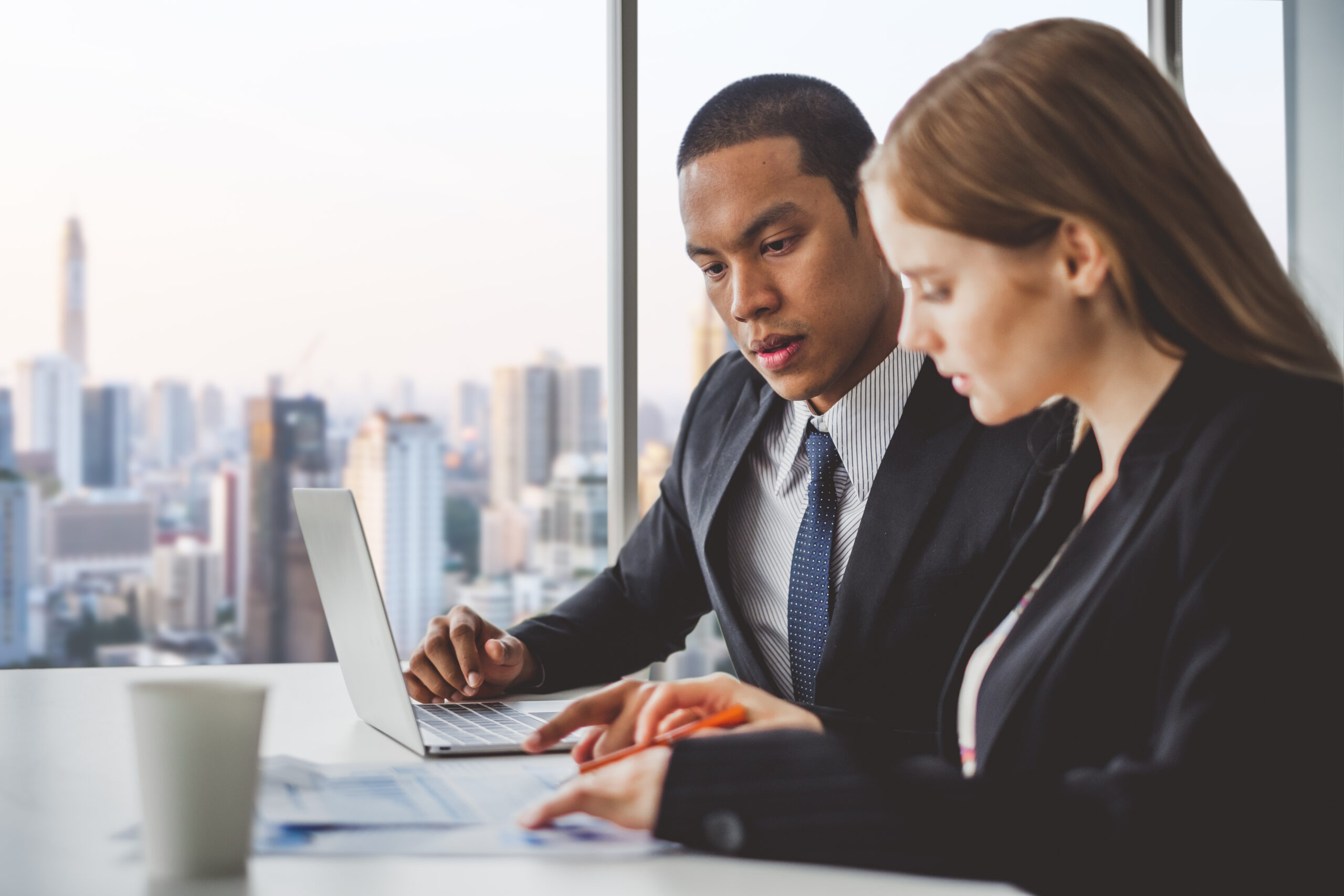 Business people discussing while meeting in office, working with laptop